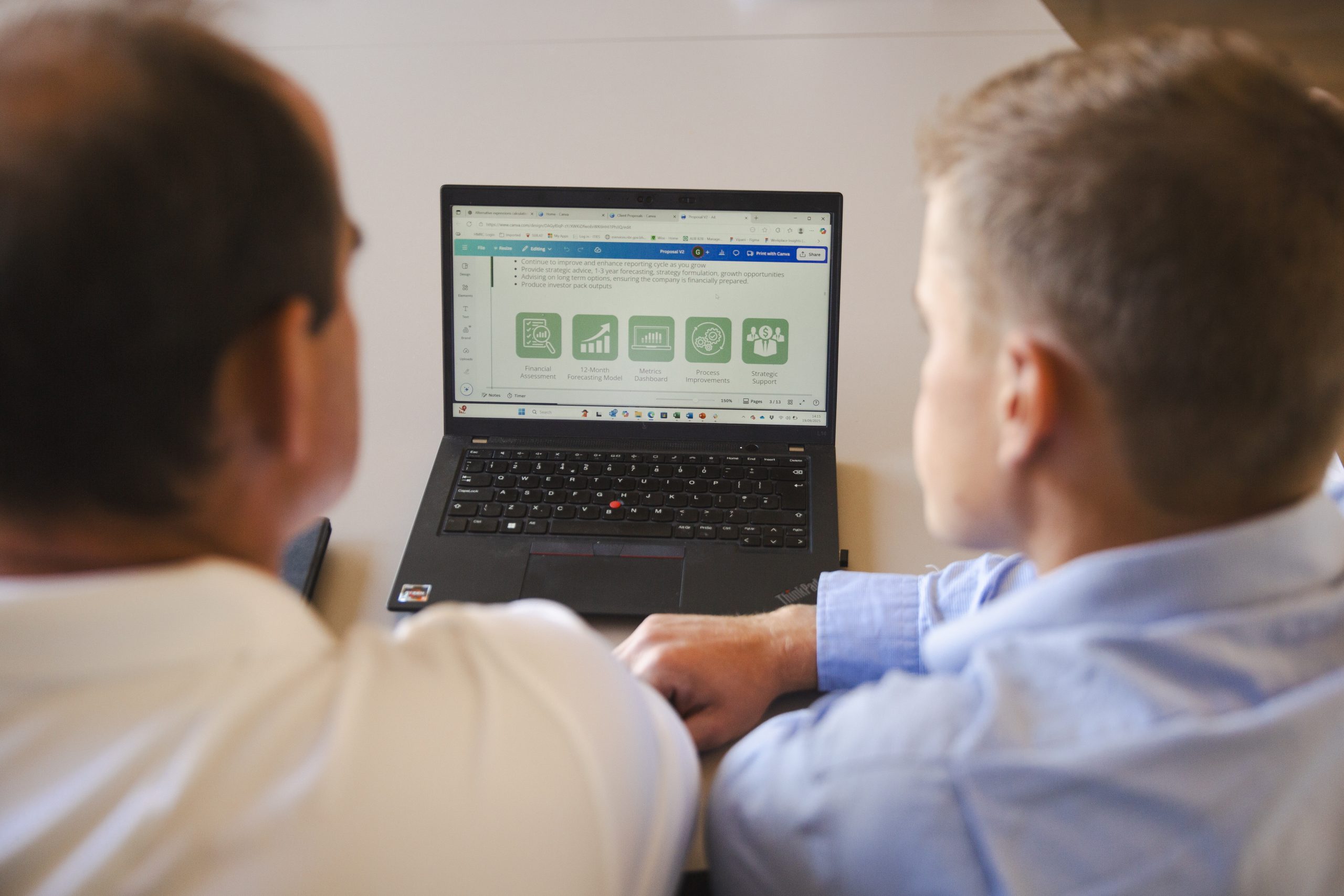 Craig and George working on a laptop together for a client on Digital Finance Transformation